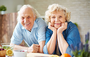 Elder couple in the kitchen smiling